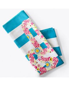 A folded beach towel with blue and white stripes, featuring a large peace sign design decorated with colorful coral and sea-themed patterns.