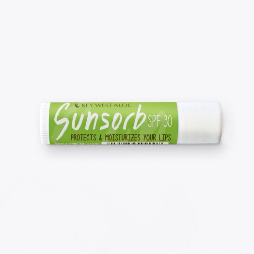 Lip balm tube labeled "Sunsorb SPF 30" with bright green packaging. Text reads "Protects & Moisturizes Your Lips" and "Key Lime Flavor." Bright, fresh look.