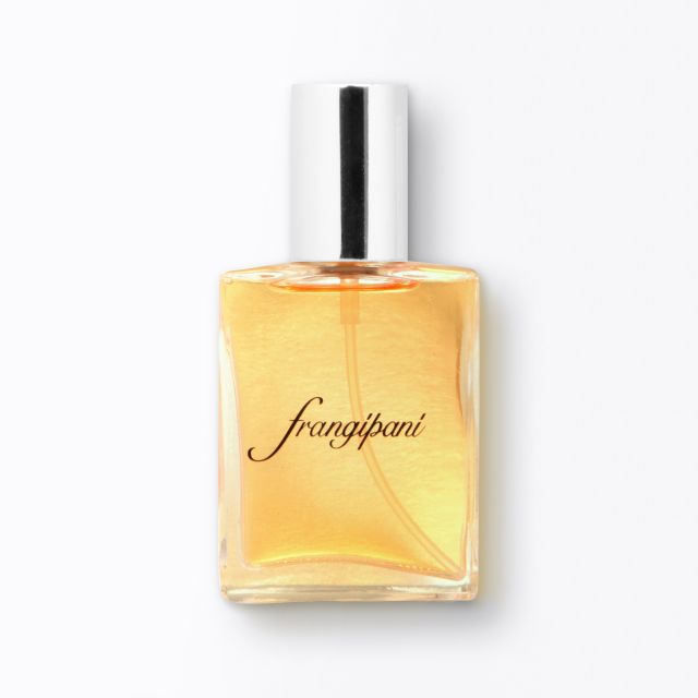 Clear glass perfume bottle with a metallic silver cap. "Frangipani" is elegantly written on its light amber liquid, conveying a fresh, floral scent.